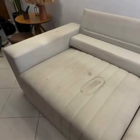Sofá claro com mancha grande no assento antes da limpeza