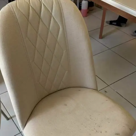 Cadeira de jantar bege com assento sujo e pontos escuros
