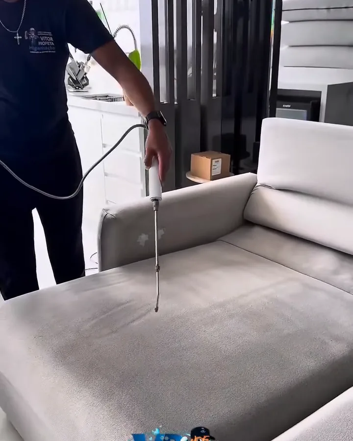 Vitor aplicando produto em um sofá durante a higienização